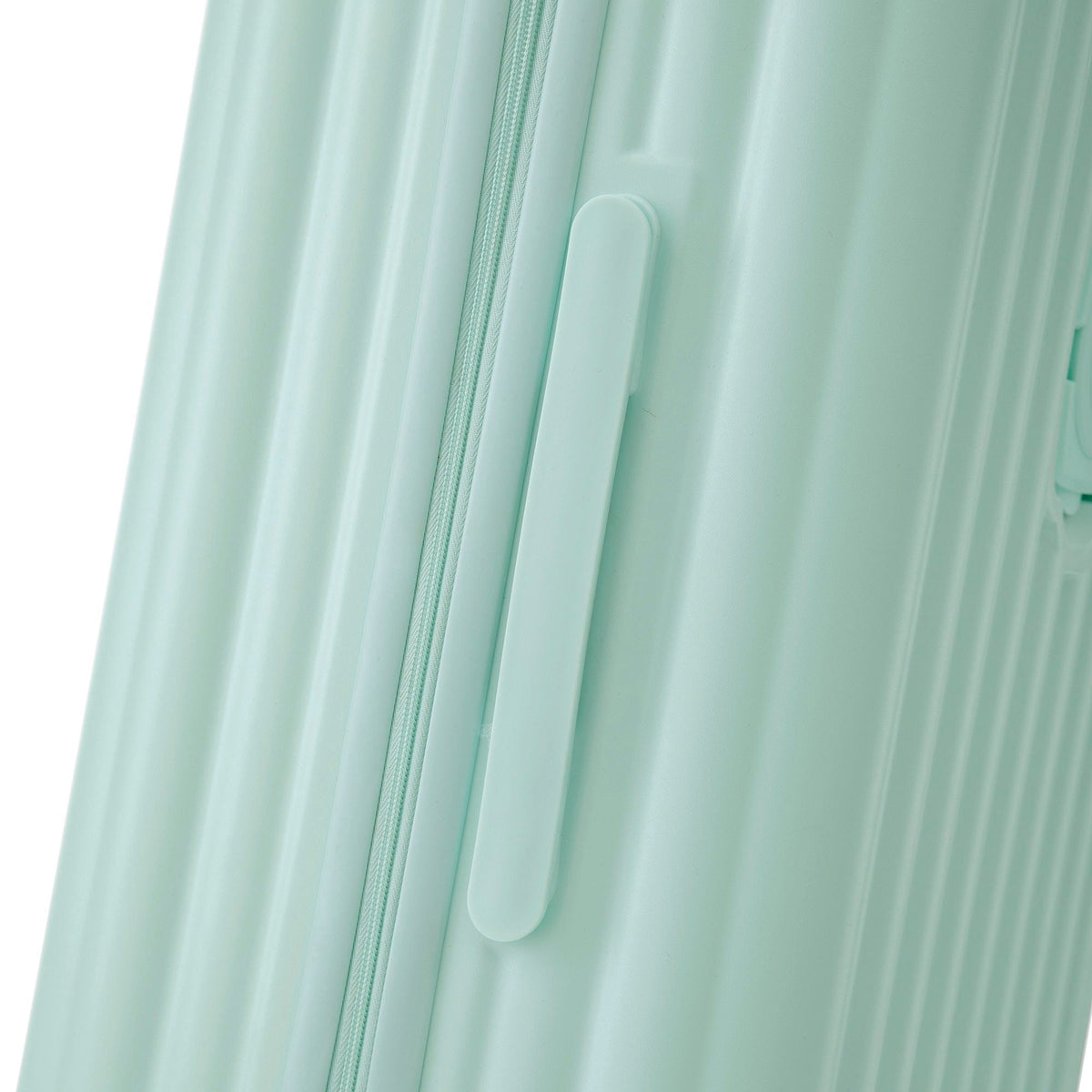 Luggage zipper close-up on mint green hard-shell carry-on with handle on Tampa Home & Garden Store