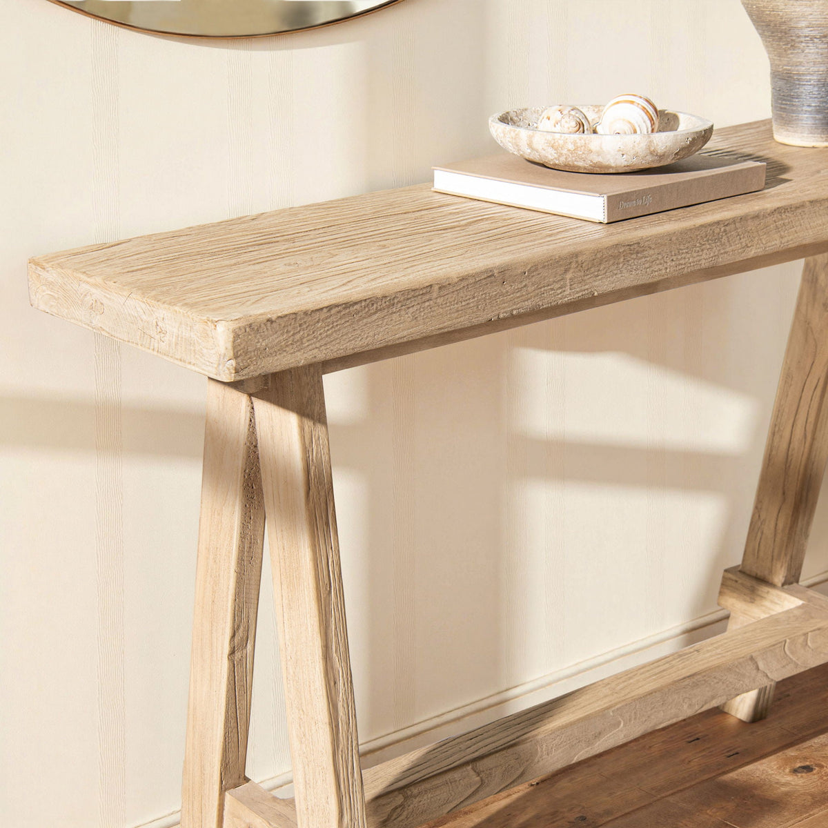 Trestle coffee table in light brown solid reclaimed elm with a bowl and book on top on Tampa Home & Garden Store