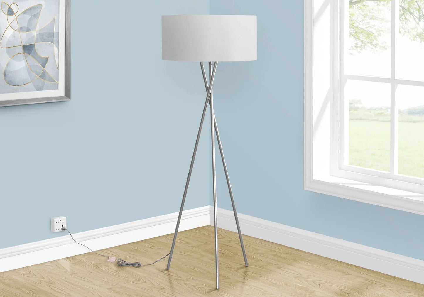 Floor lamp with silver tripod legs and white drum shade in a blue-walled room on Tampa Home & Garden Store