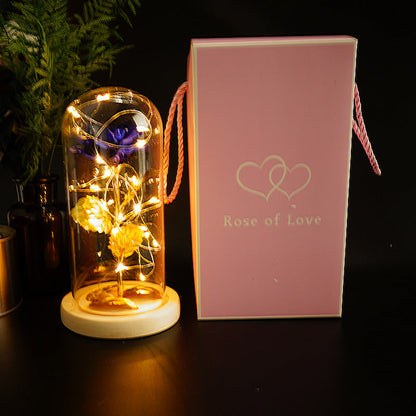 Gold foil rose under glass dome with warm LEDs on a wooden base beside Rose of Love on Tampa Home & Garden Store