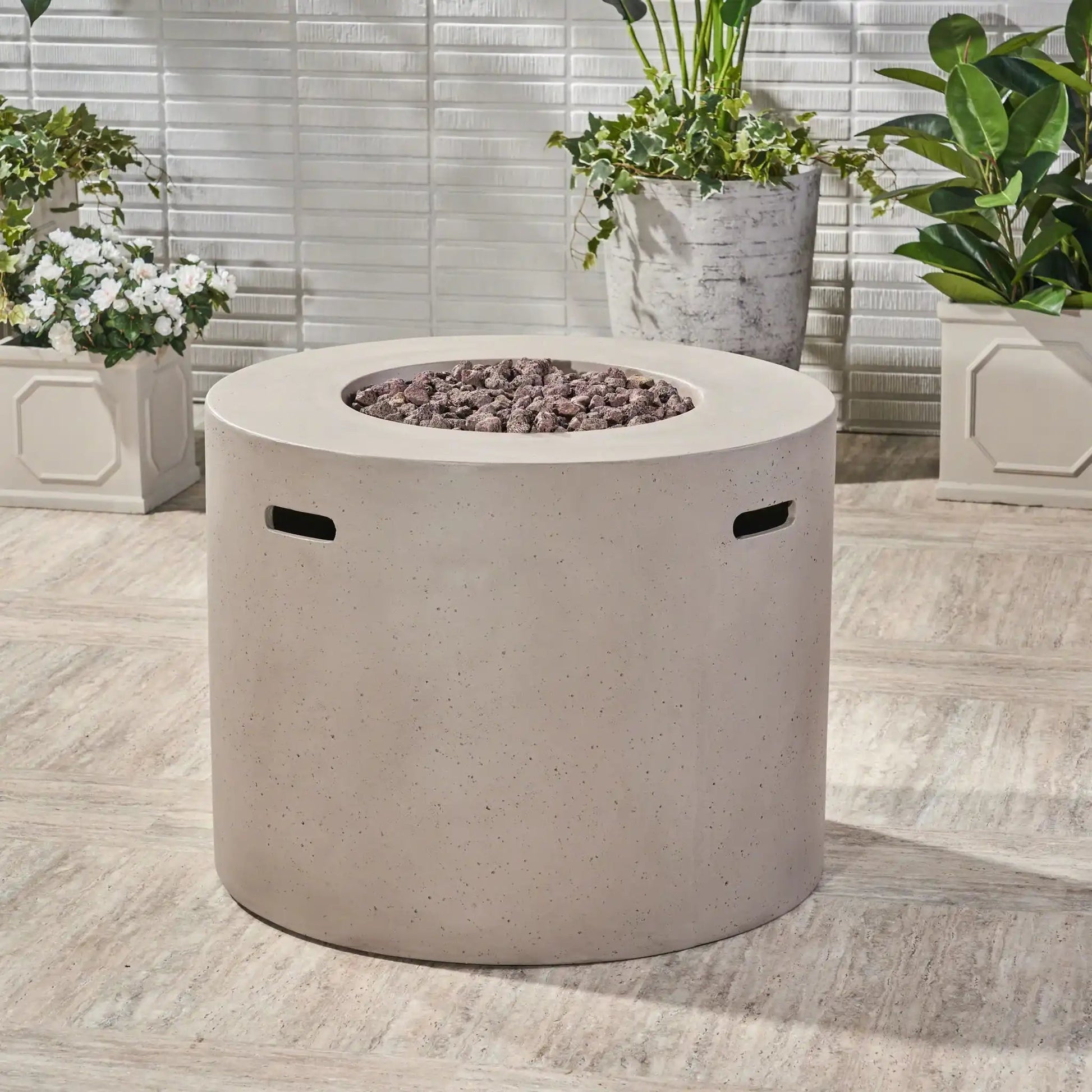 Round iron fire pit with 40,000 BTU, lava rock fill, gray speckled exterior in outdoor setting on Tampa Home & Garden Store