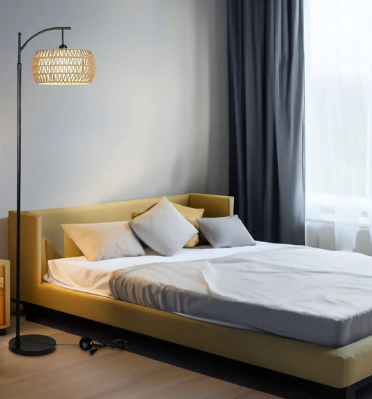 Arc floor lamp with woven beige shade and black metal base beside a yellow bed in a modern room on Tampa Home & Garden Store