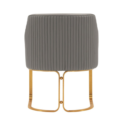 Arm chair with dark gray quilted upholstery featuring vertical channel stitching and brass legs on Tampa Home & Garden Store