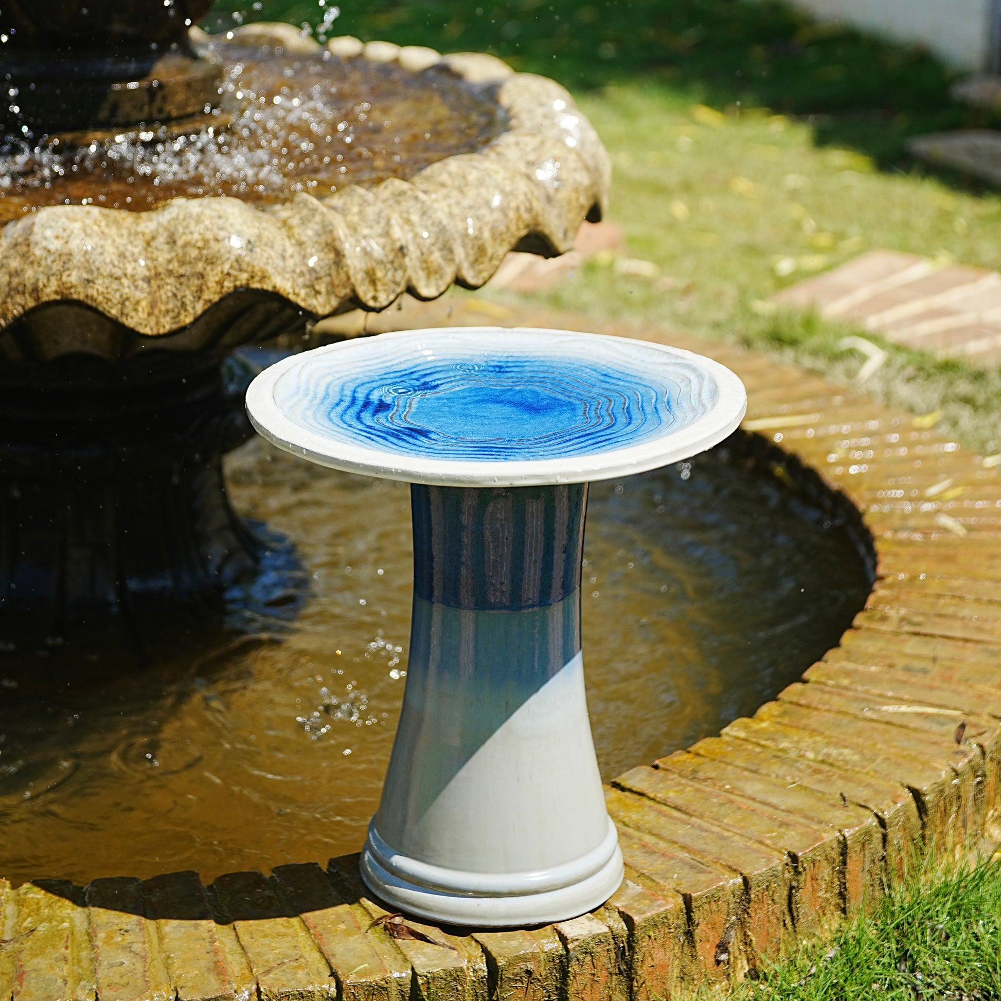 Handmade glazed ceramic bird bath with blue swirl saucer on a striped pedestal on Tampa Home & Garden Store