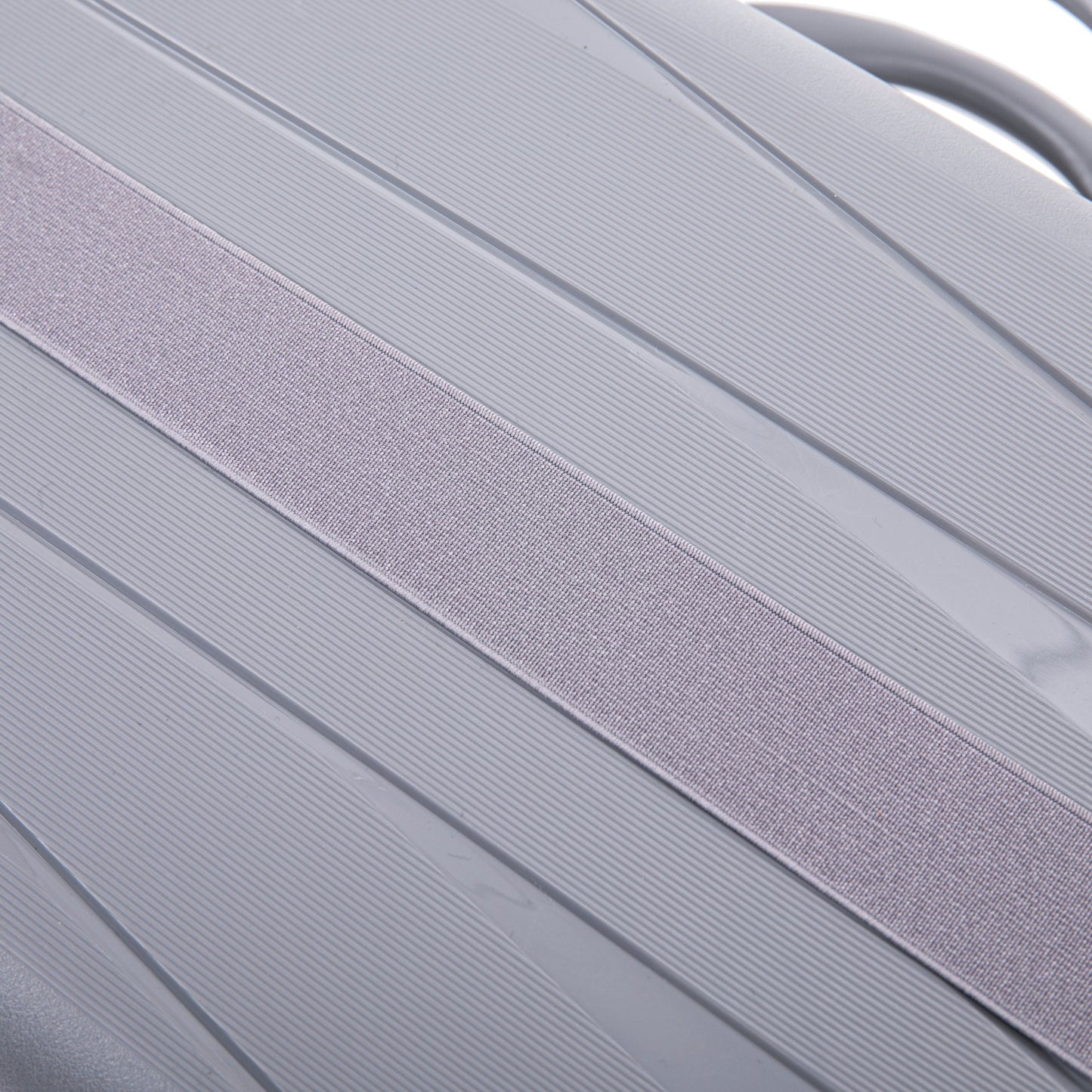 Luggage strap light gray fabric across ribbed hard-shell surface on Tampa Home & Garden Store