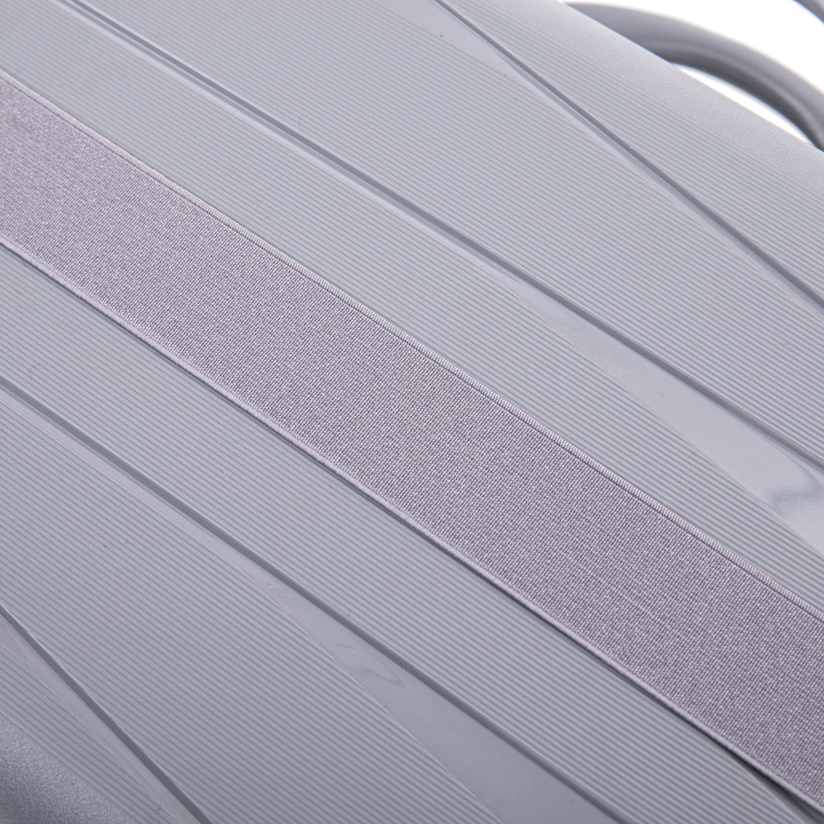 Luggage strap light gray fabric across ribbed hard-shell surface on Tampa Home & Garden Store