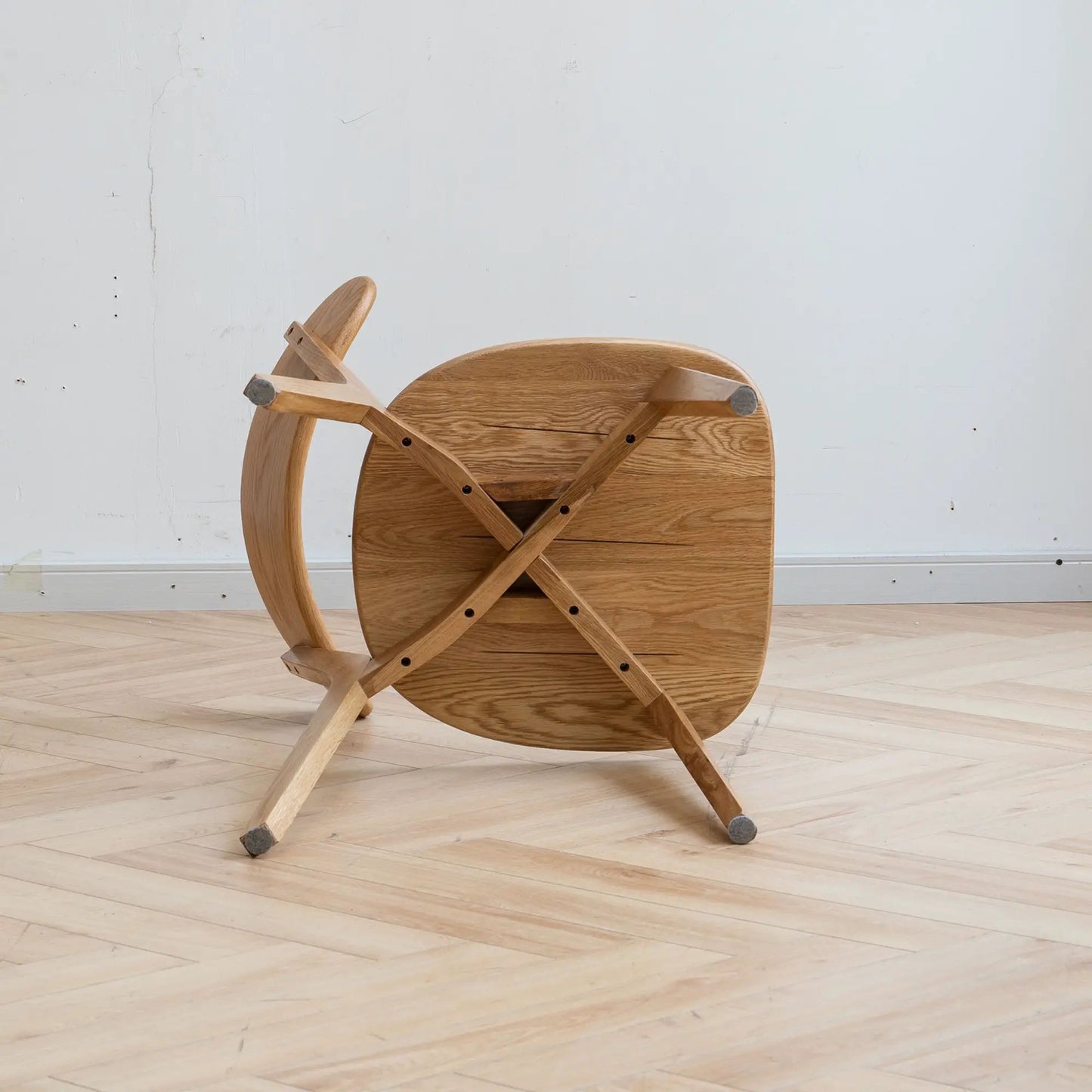 Simple dining chair in light oak with round wood seat and cross-braced legs on Tampa Home & Garden Store