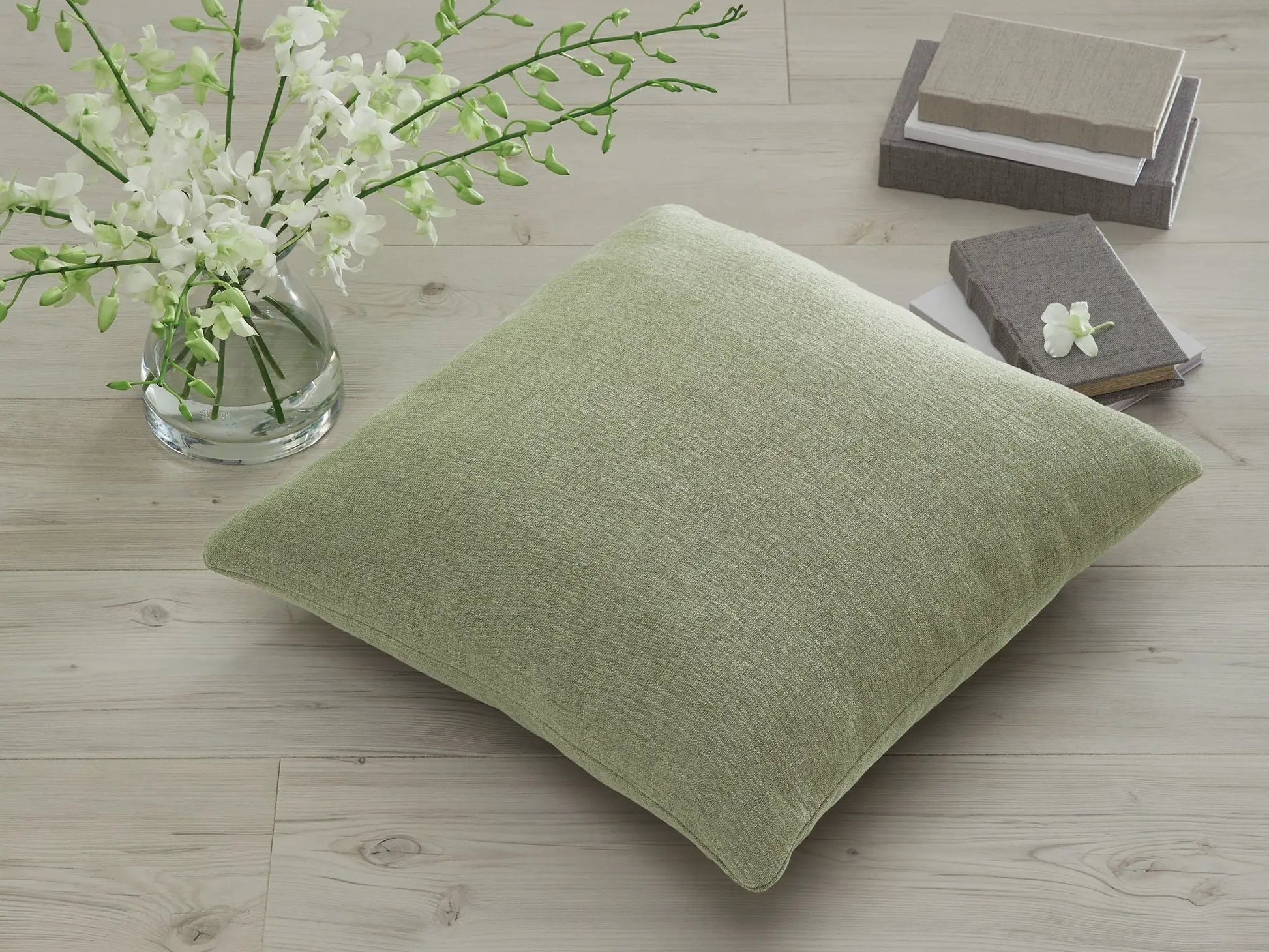 Brockbert throw pillow in sage green textured fabric with neutral swatches and white vase on Tampa Home & Garden Store