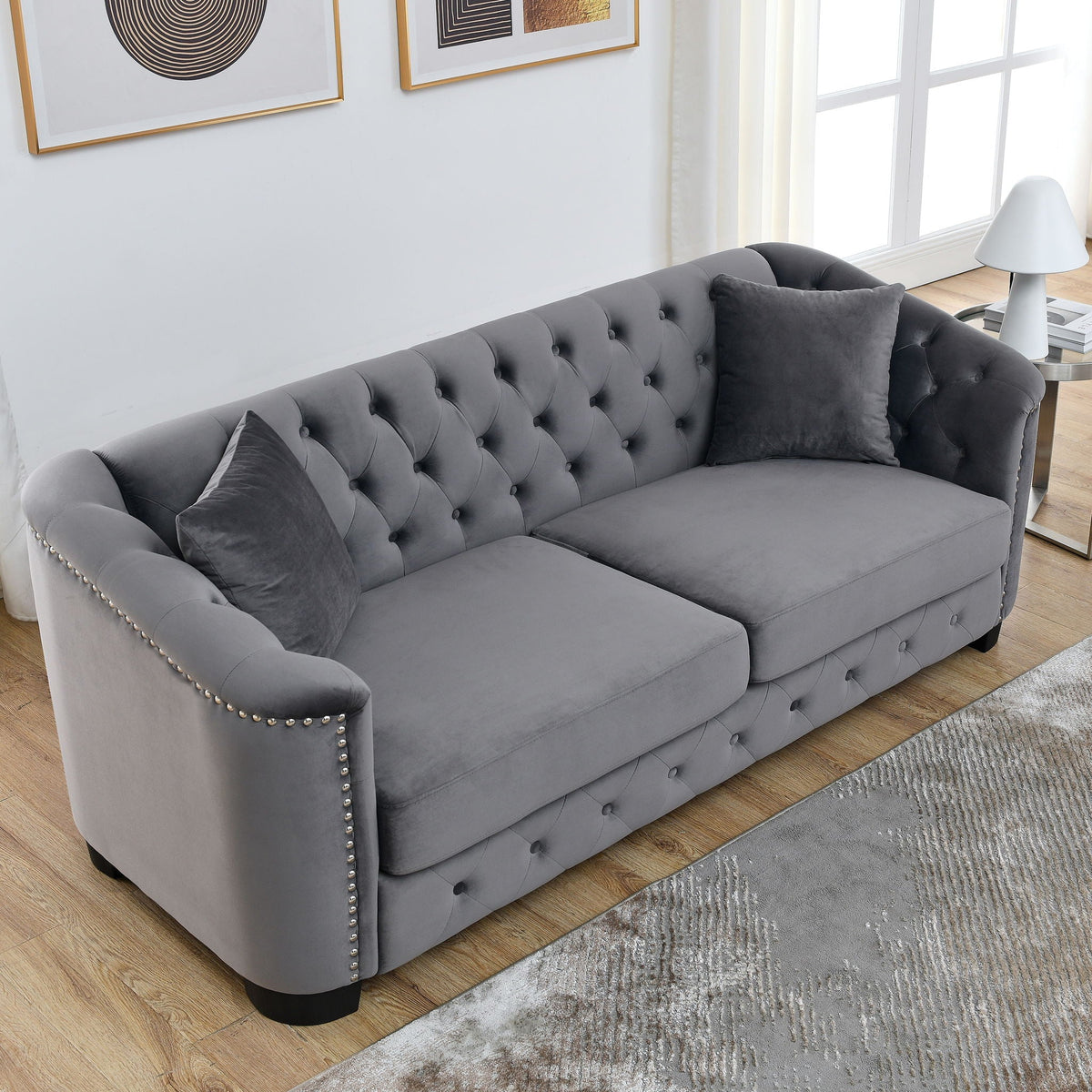 Modern Chesterfield sofa with tufted backrest in gray upholstery, studded arms stationary on Tampa Home & Garden Store