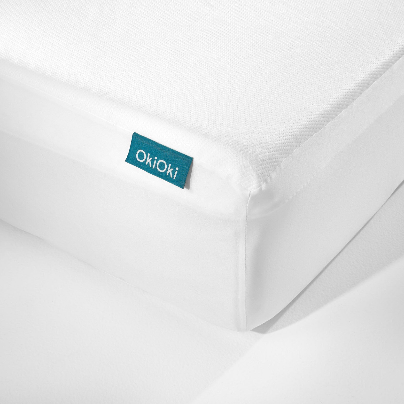 OkiOki King Mattress Protector white knit fabric with blue OkioKi label on Tampa Home & Garden Store