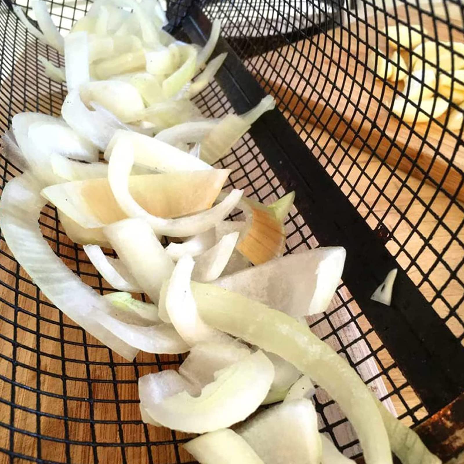 Perfecsy rolling grilling basket black metal BBQ basket with onion peels inside on Tampa Home & Garden Store