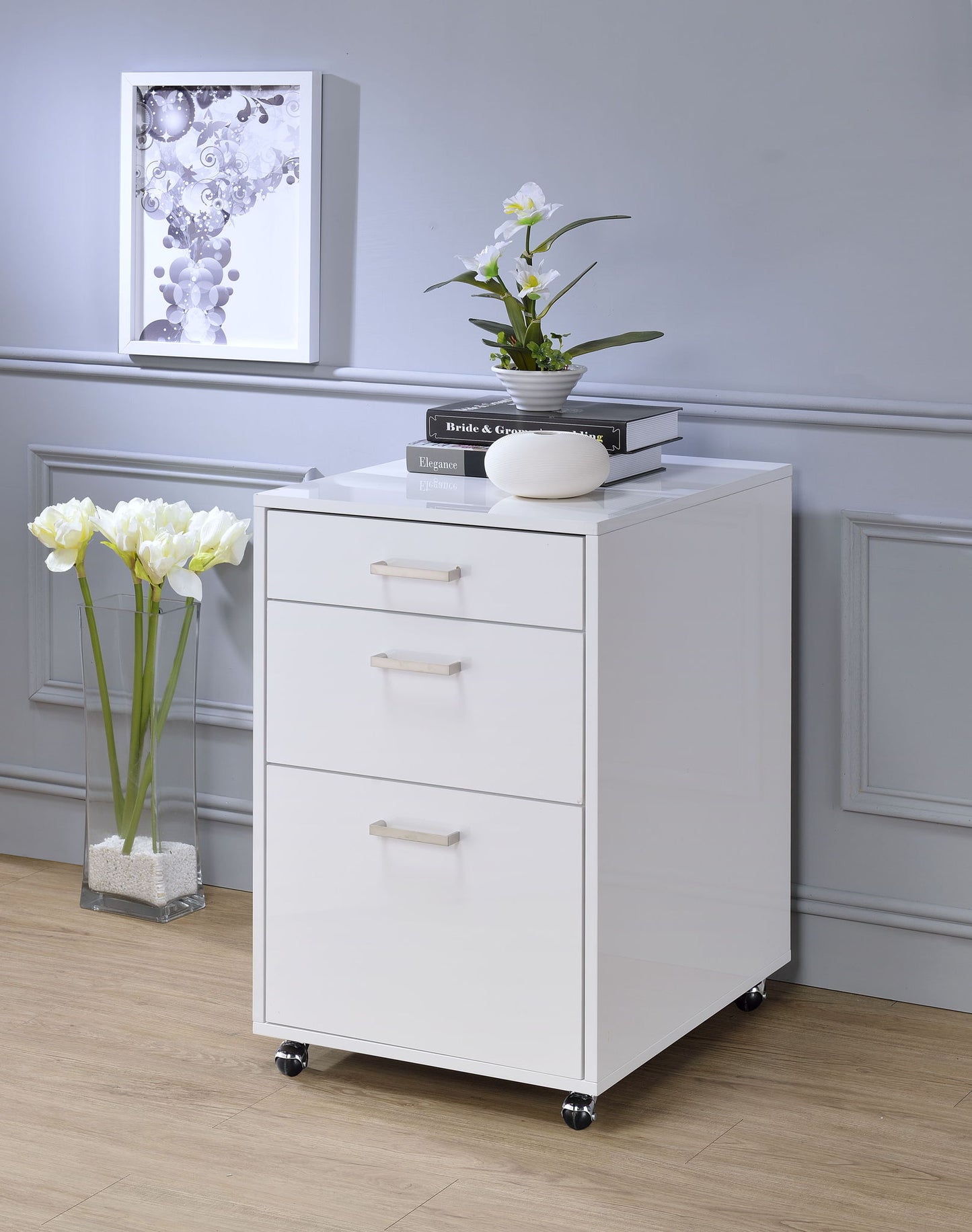 Coleen high gloss white filing cabinet with 3 drawers on casters topped by books and orchid on Tampa Home & Garden Store