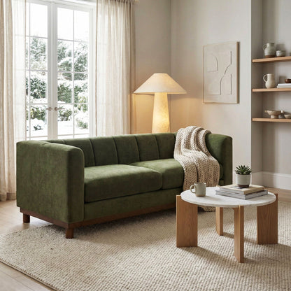 Green velvet stationary loveseat with wooden legs, draped with a chunky knit throw on Tampa Home & Garden Store