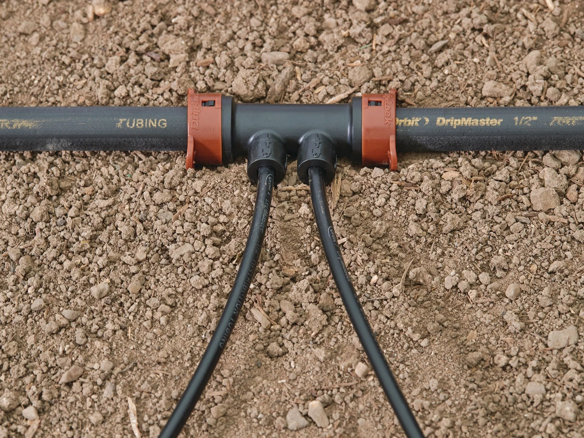 Orbit Irrigation Drip-Lock 2-port manifold gray body with orange clamps and two hoses connected on Tampa Home & Garden Store