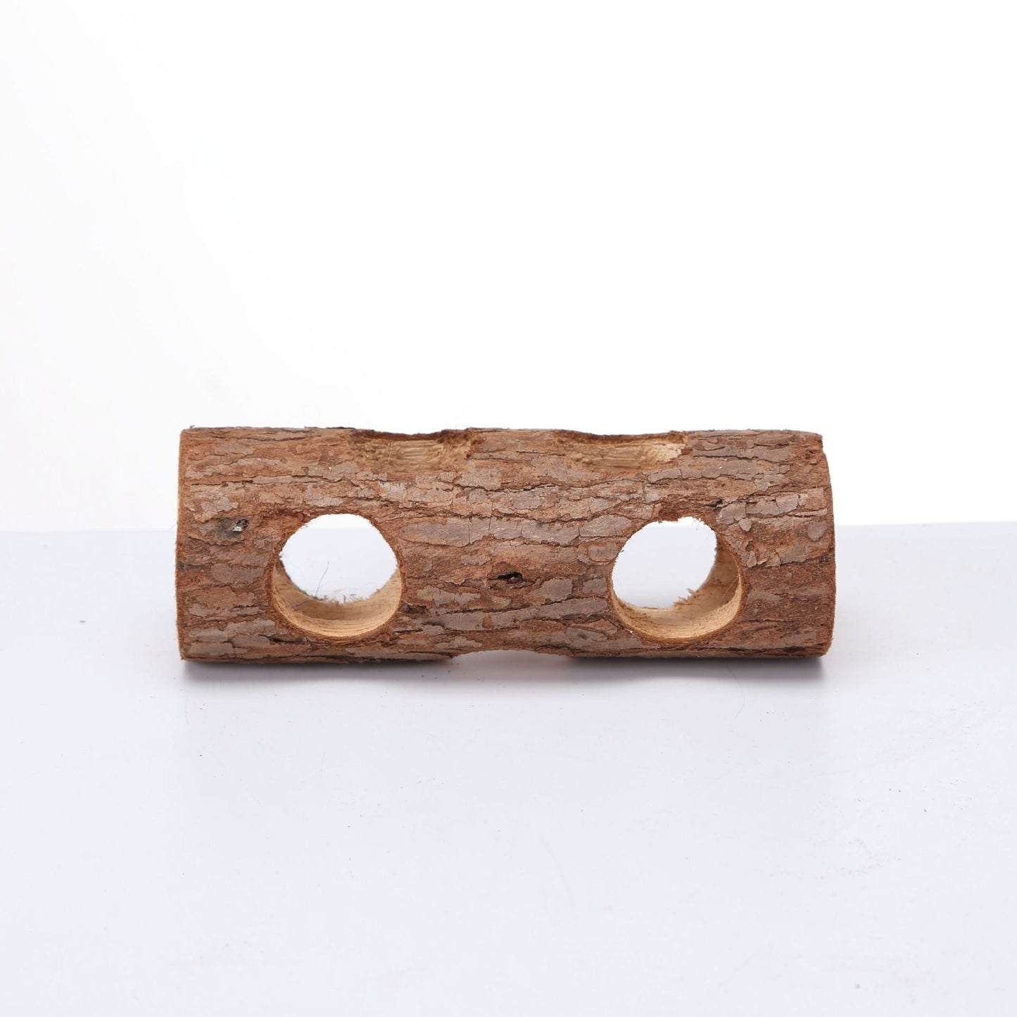 Solid wood bird toy log with bark texture and two circular holes on Tampa Home & Garden Store