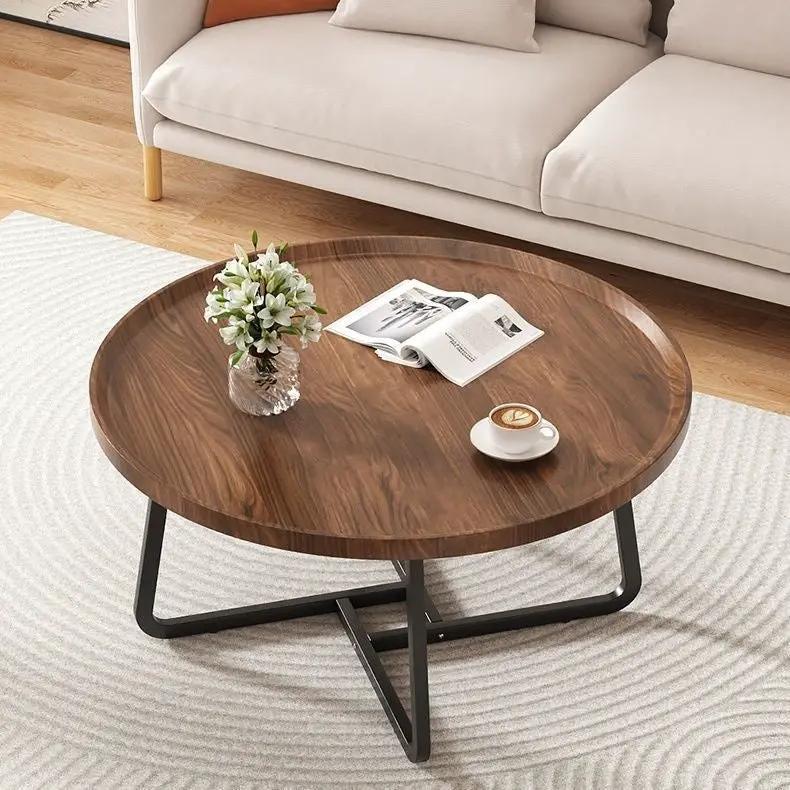 Round solid wood tea table with black metal legs in a living room with vase and cup on Tampa Home & Garden Store
