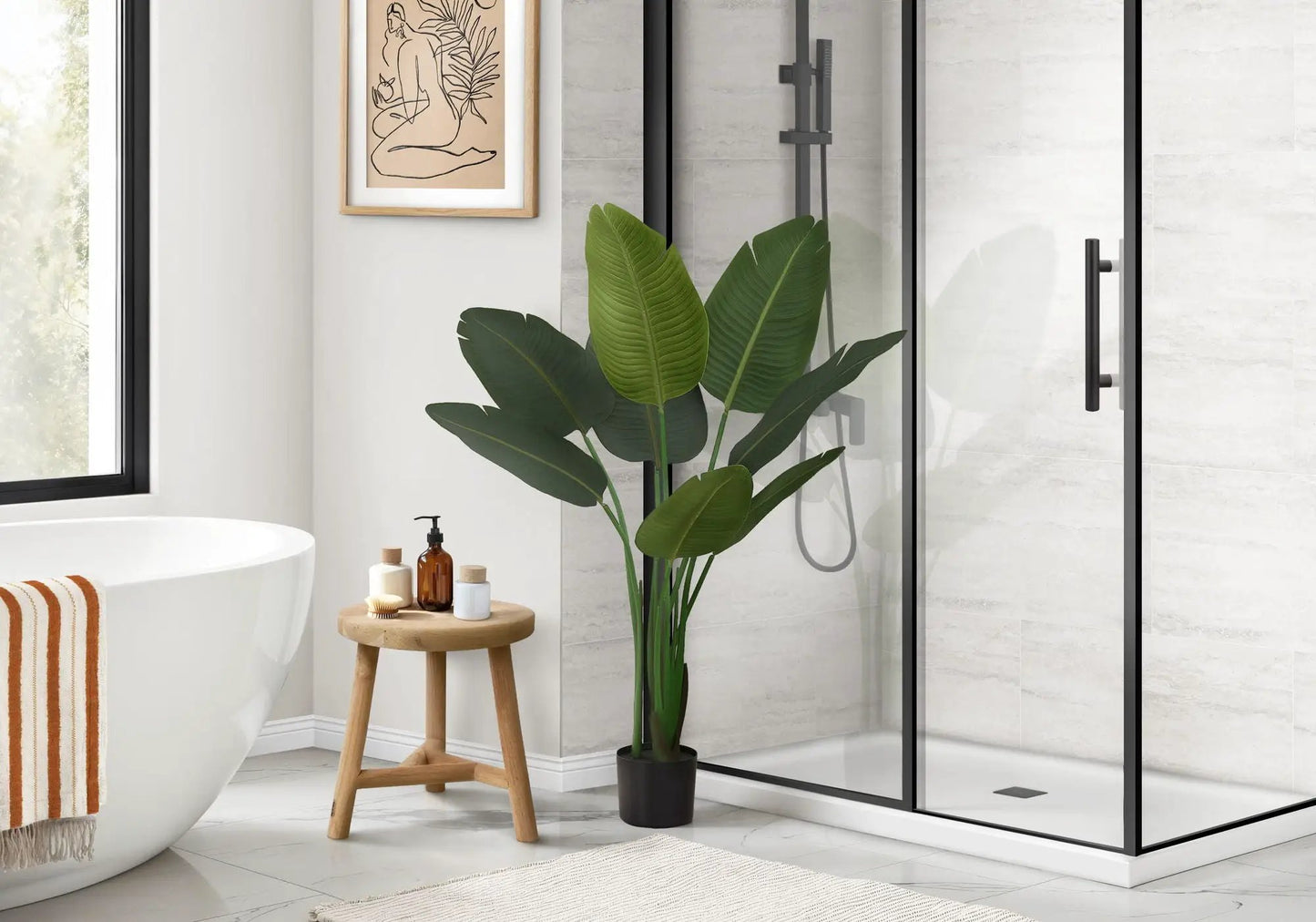 Bird of Paradise faux plant, 44 in tall in black pot with green leaves beside shower in bathroom on Tampa Home & Garden Store