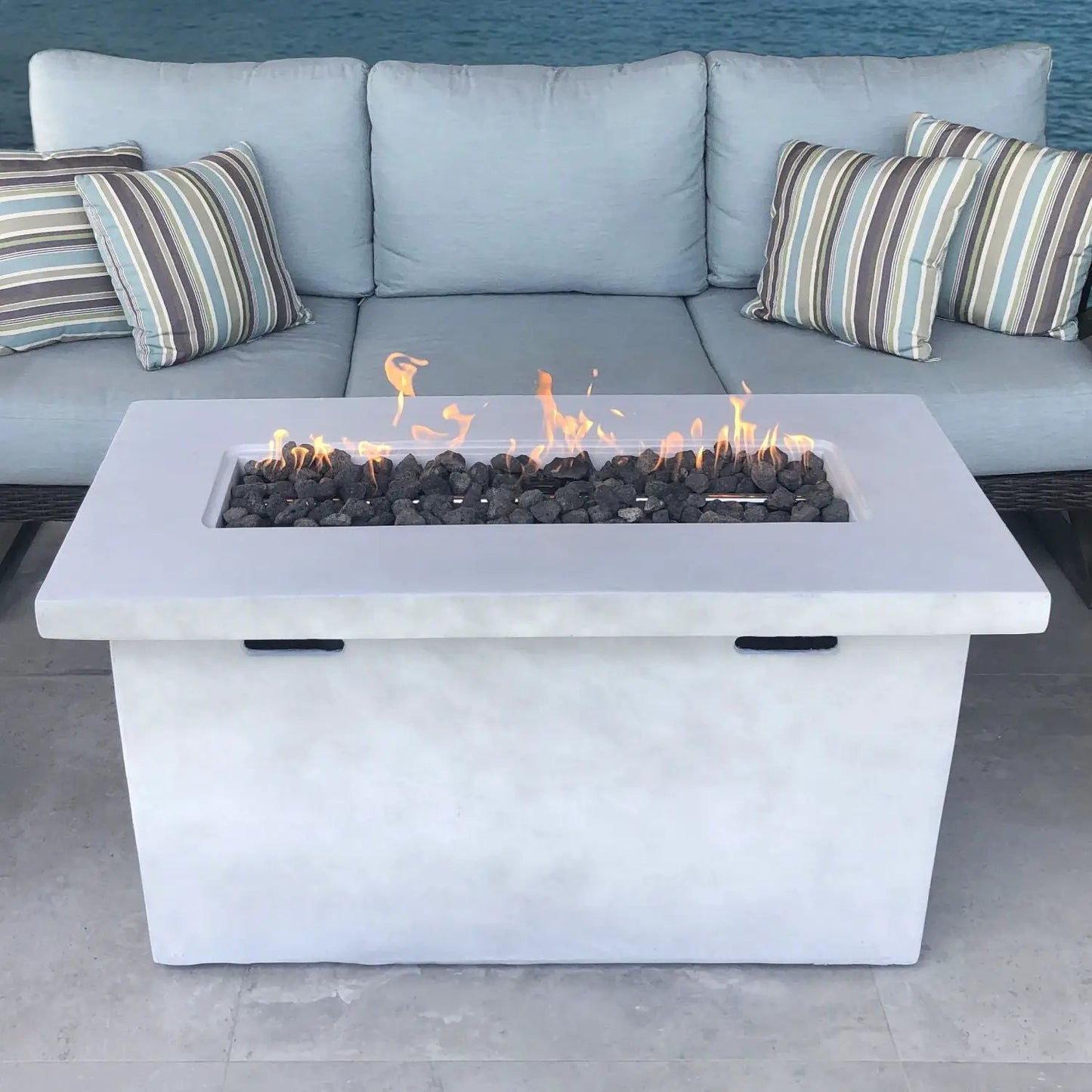 Reinforced propane outdoor fire pit table in white concrete with lava rock and flames on Tampa Home & Garden Store