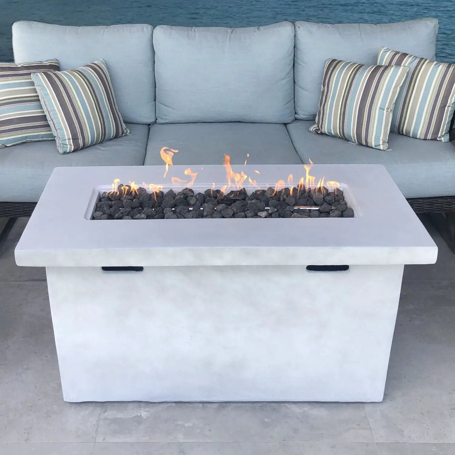 Reinforced propane outdoor fire pit table in white concrete with lava rock and flames on Tampa Home & Garden Store