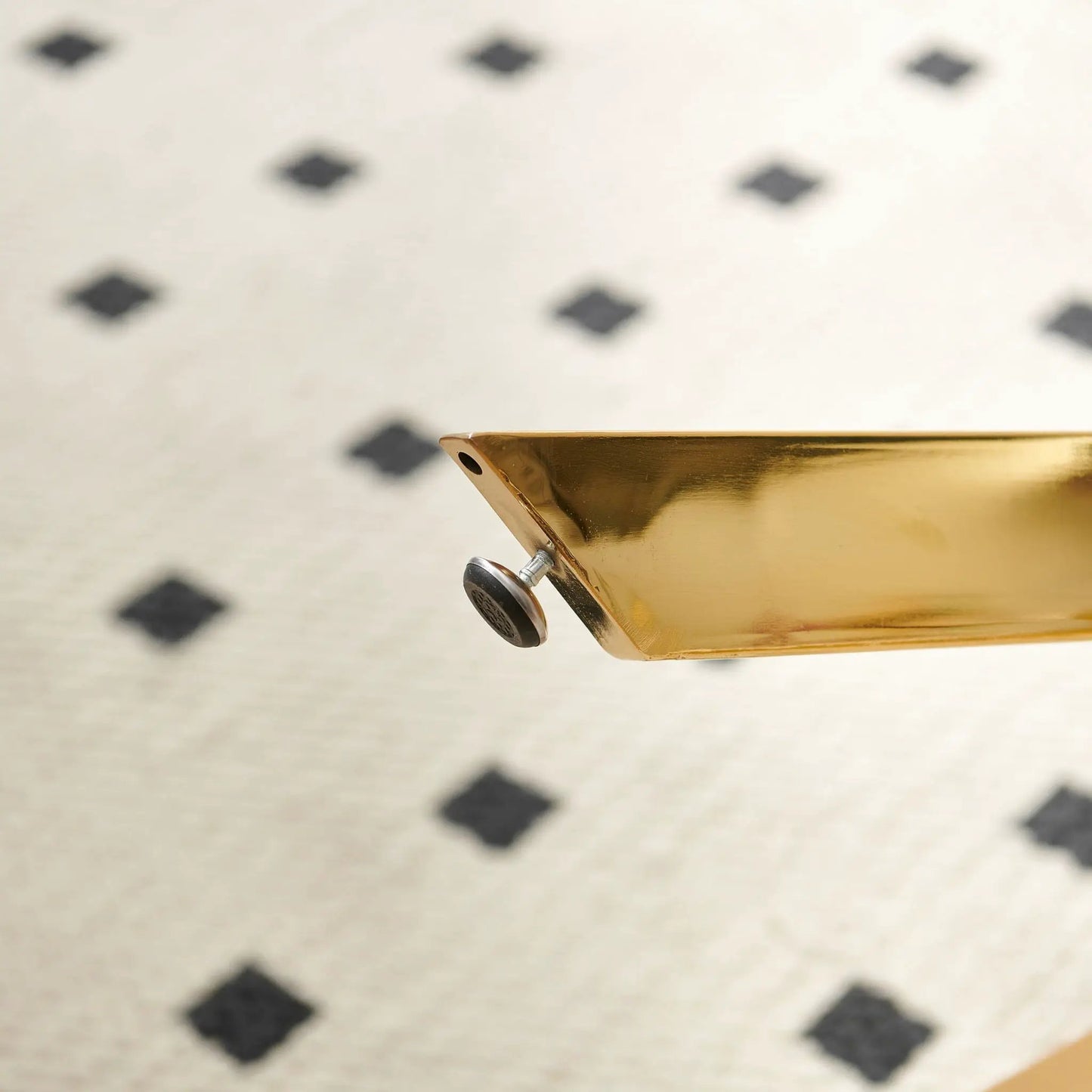 Dining table edge in gold-tone metal with curved corner detail on Tampa Home & Garden Store