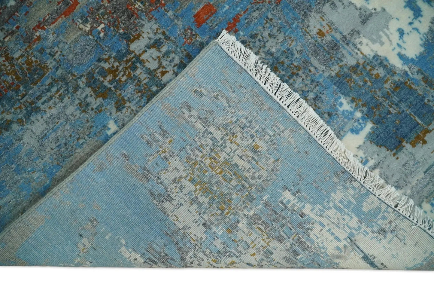 Beige and blue hand knotted wool and silk area rug with abstract pattern and fringe edge on Tampa Home & Garden Store