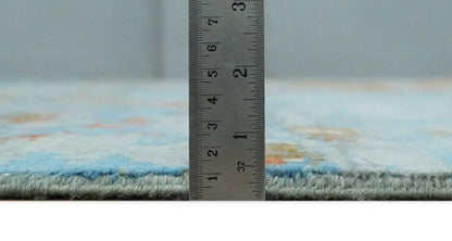 Beige and blue hand-knotted wool and silk area rug shown with a ruler for scale on Tampa Home & Garden Store