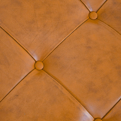 Light tan leather upholstered ottoman with diamond tufting and round button accents on Tampa Home & Garden Store