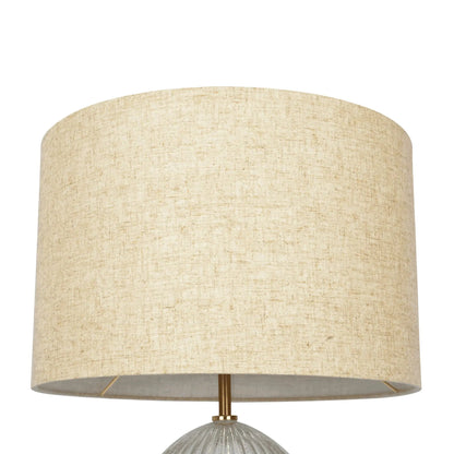 Table lamp with large beige linen shade and ribbed clear base with gold hardware on Tampa Home & Garden Store