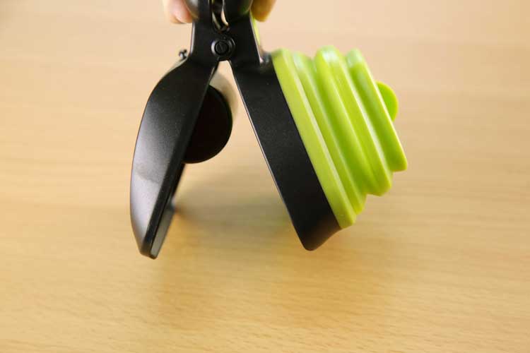 Pet Zen foldable dog poop scooper with black body and green bag roll for waste pickup on Tampa Home & Garden Store