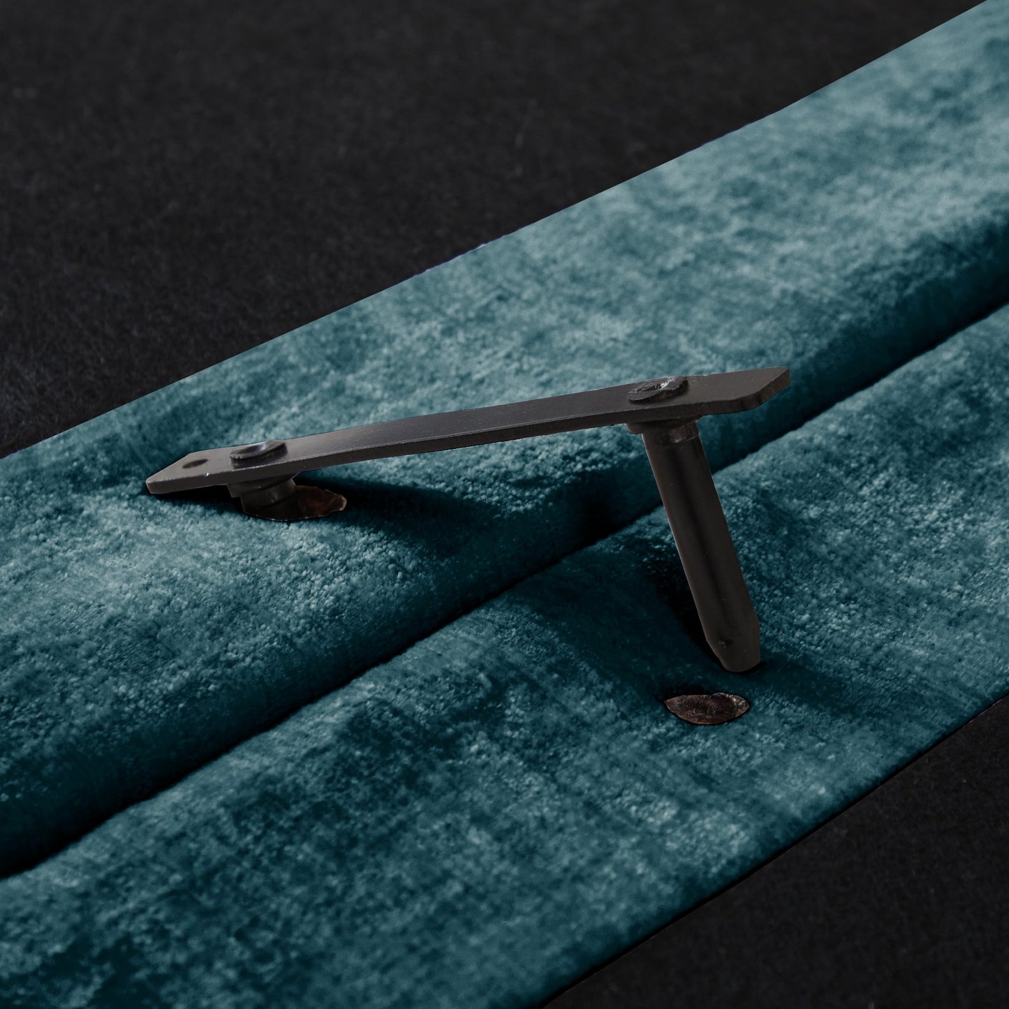 Sofa leg hardware by HouseOfZazla in dark metal with bolt detail on teal carpet on Tampa Home & Garden Store