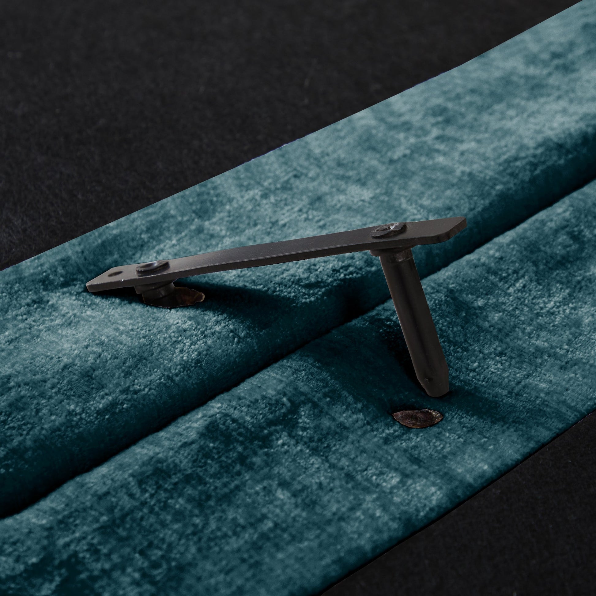 Sofa leg hardware by HouseOfZazla in dark metal with bolt detail on teal carpet on Tampa Home & Garden Store