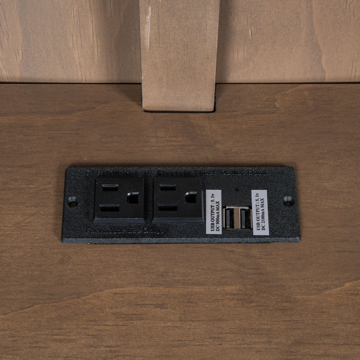 Black power strip with three outlets and USB port on dark wood desk on Tampa Home & Garden Store