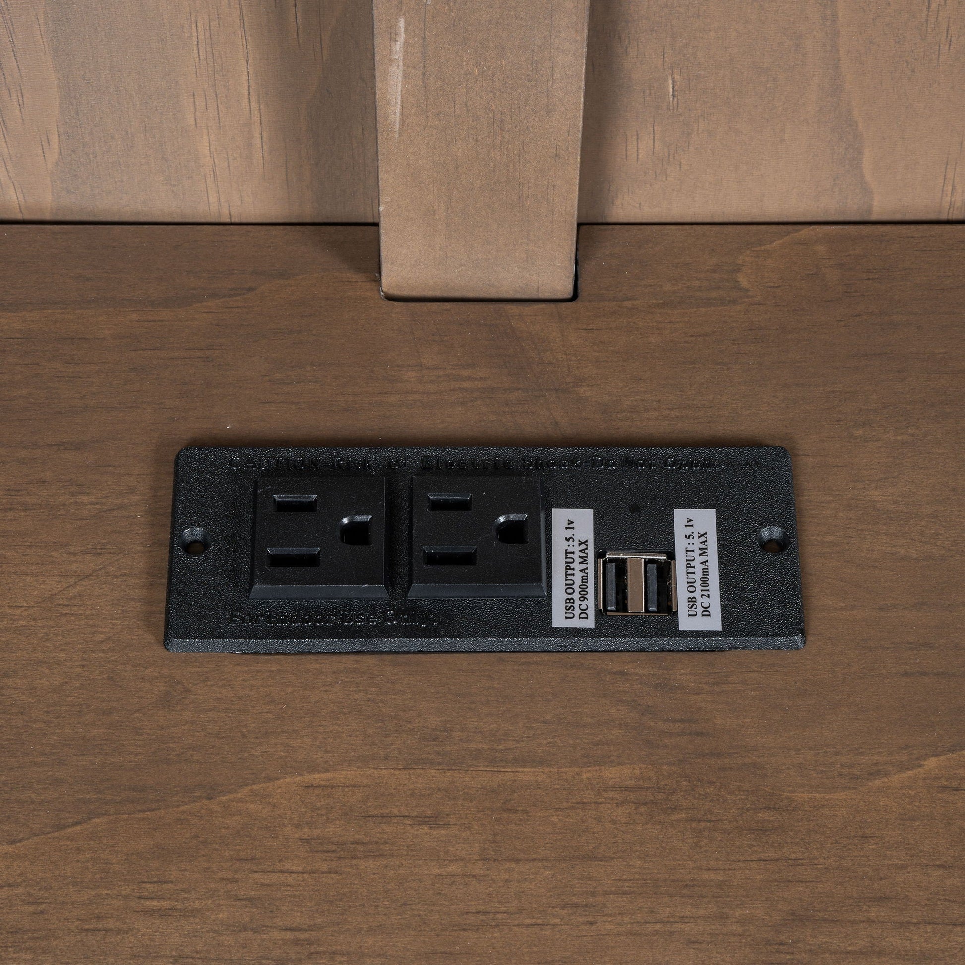 Black power strip with three outlets and USB port on dark wood desk on Tampa Home & Garden Store