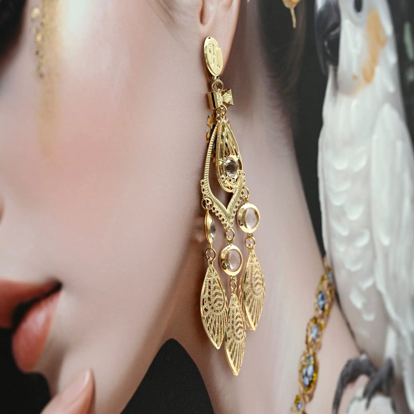 Gold statement necklace with crystal pendants and intricate filigree on ivory fabric on Tampa Home & Garden Store