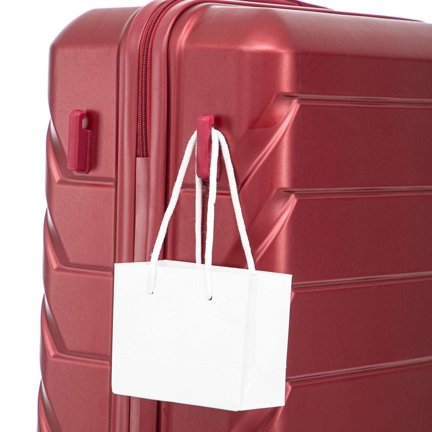 HouseOfZazla red hard-shell spinner luggage with white tag on Tampa Home & Garden Store
