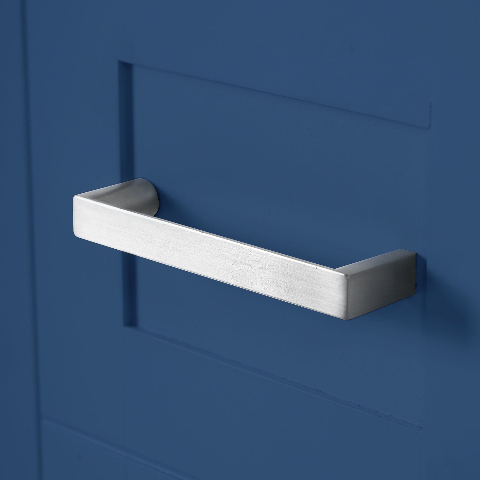 Bathroom vanity drawer pull, single silver brushed-metal handle on blue surface on Tampa Home & Garden Store