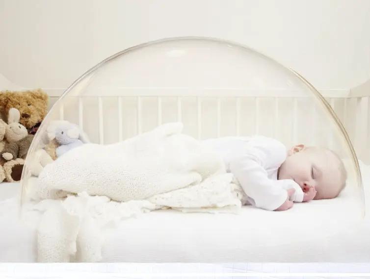 Baby pacifying sleep dome over white crib with sleeping infant; clear bubble canopy on Tampa Home & Garden Store
