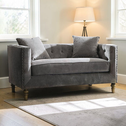Gray Sidonia loveseat in velvet with button tufting and two pillows; nailhead trim and wood legs on Tampa Home & Garden Store