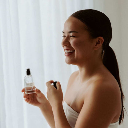 Flaura Eau De Parfum spray bottle by UpCircle held by smiling woman on Tampa Home & Garden Store