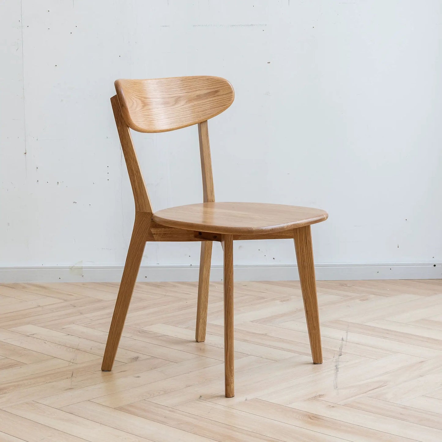 Simple dining chair in natural oak with curved back and rounded seat on Tampa Home & Garden Store