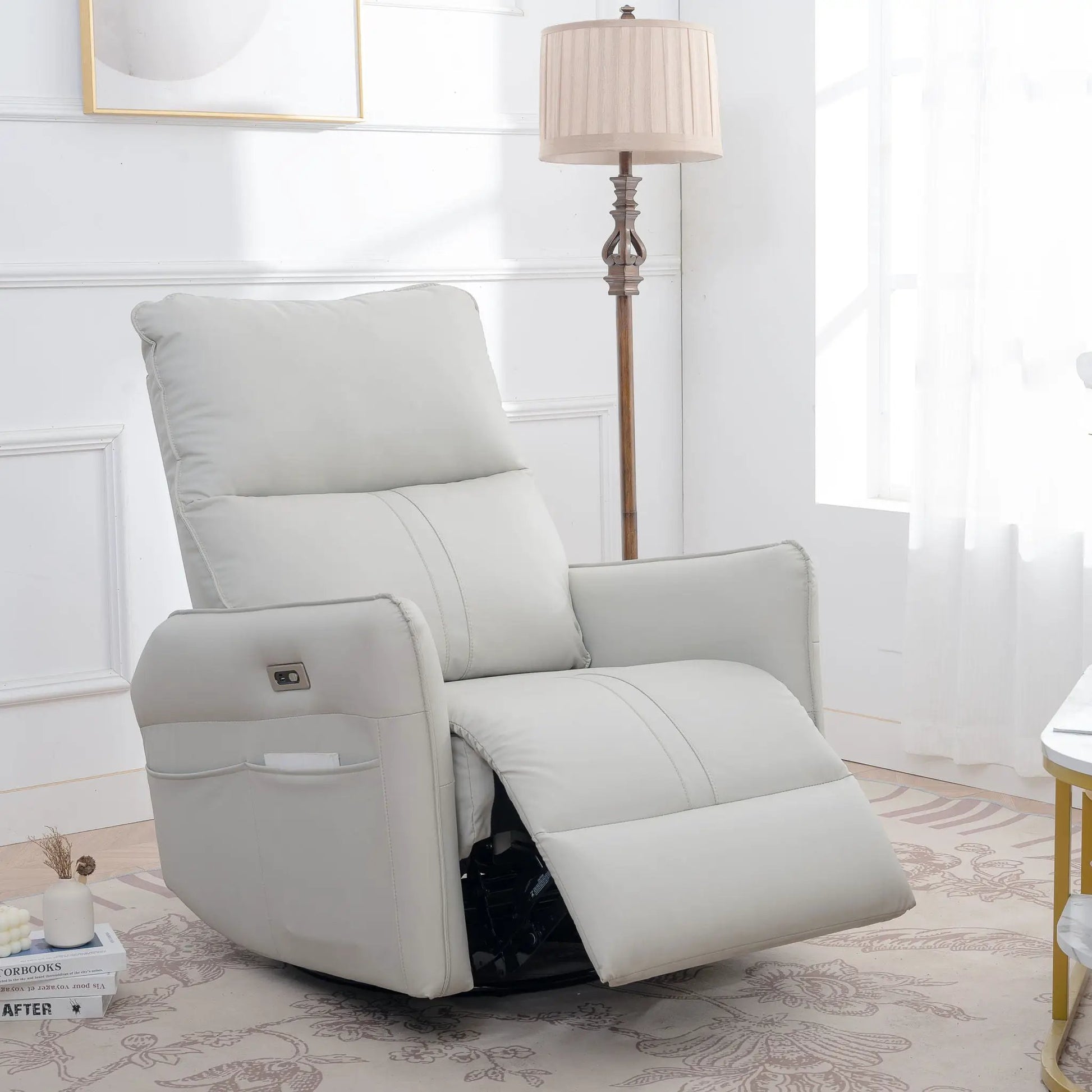 Power swivel rocker recliner chair in light gray leather with USB ports, shown in a living room on Tampa Home & Garden Store