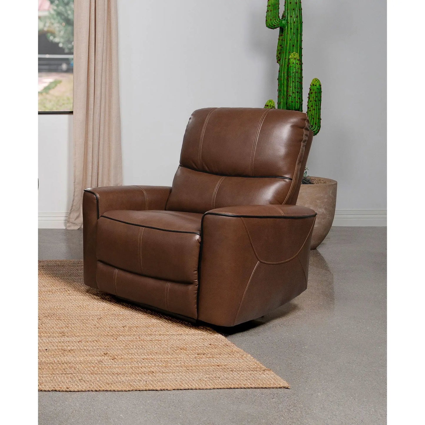 Unique Piece Furniture Denson brown power recliner with stitched seams beside a cactus on Tampa Home & Garden Store