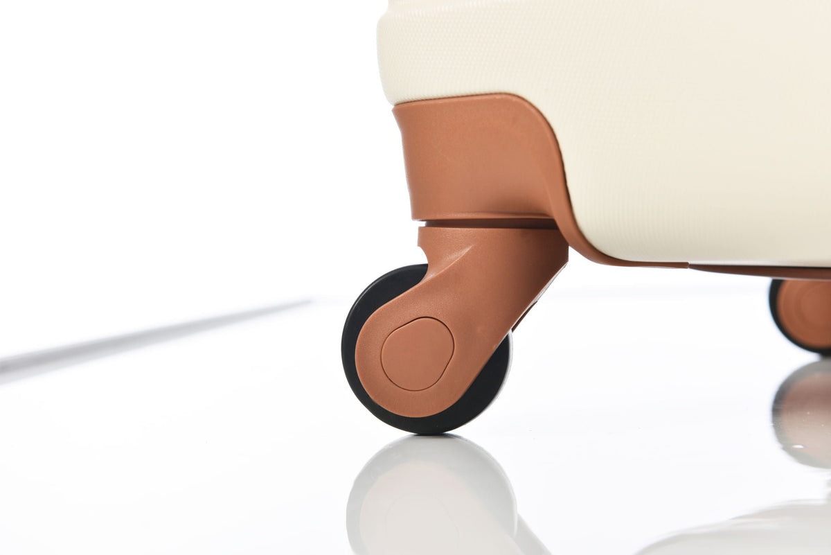 HouseOfZazla luggage wheel closeup on beige hardside spinner with brown trim on Tampa Home & Garden Store