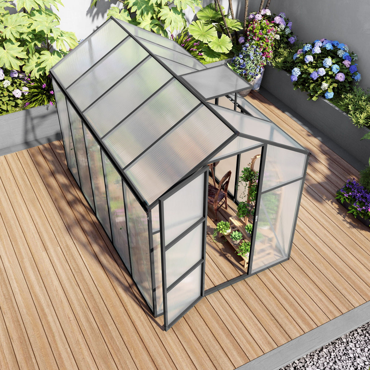 Windproof greenhouse with black frame and polycarbonate panels on a wooden deck beside hydrangeas on Tampa Home & Garden Store