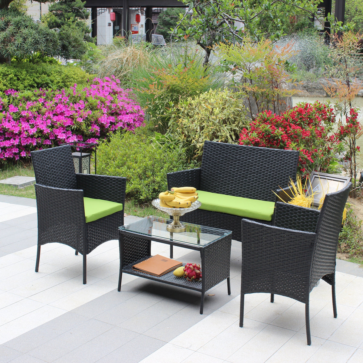 4 pc rattan patio furniture set with black wicker and green cushions around a glass table on Tampa Home & Garden Store