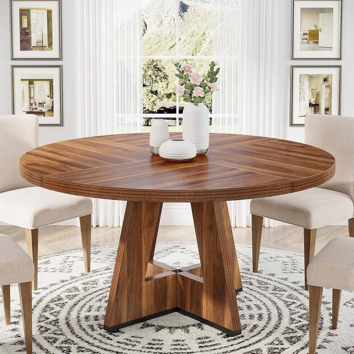 Round wooden dining table with cross pedestal base, beige chairs and white ribbed vases on Tampa Home & Garden Store