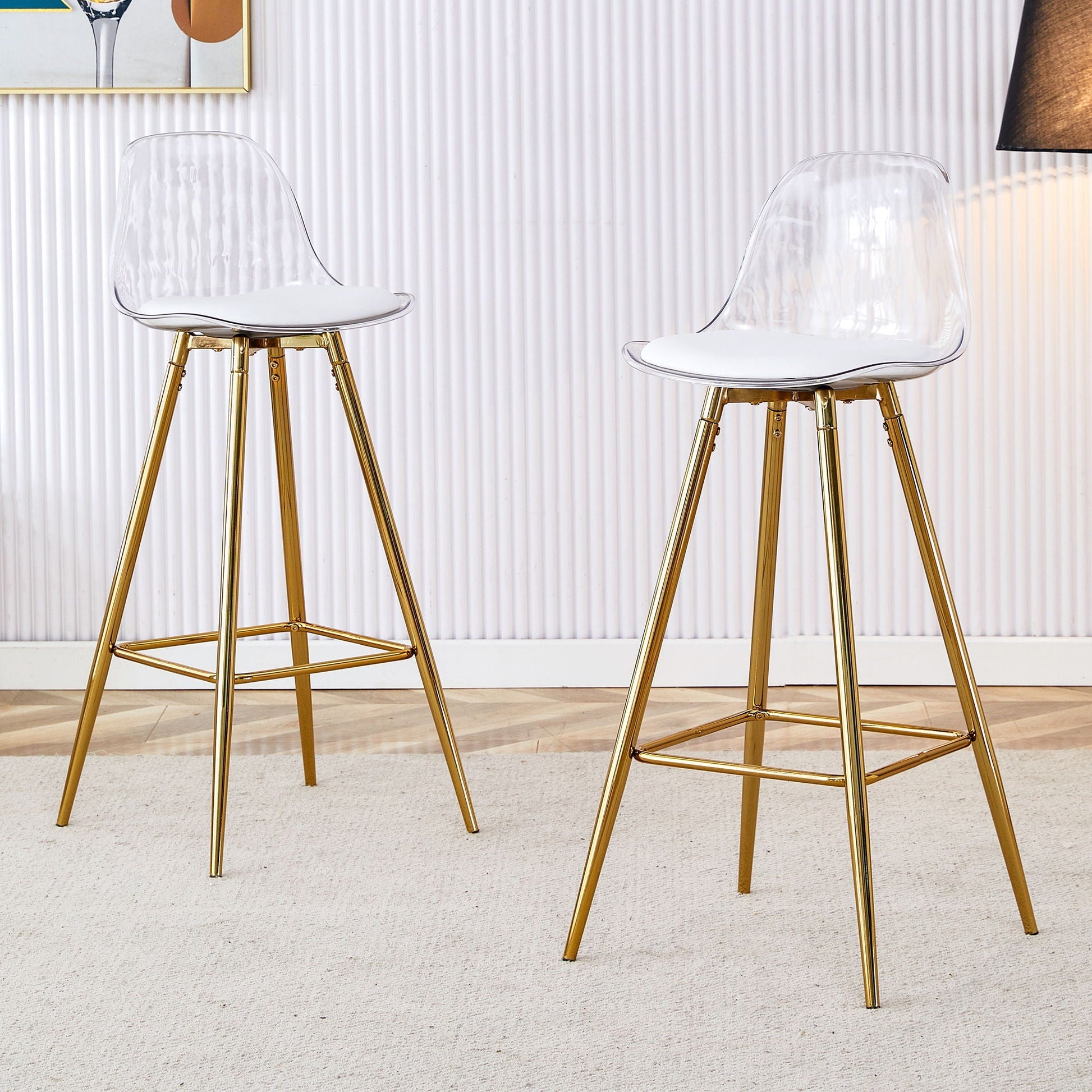 Two stylish upholstered bar chairs with clear shells, white cushions, and gold metal legs on Tampa Home & Garden Store