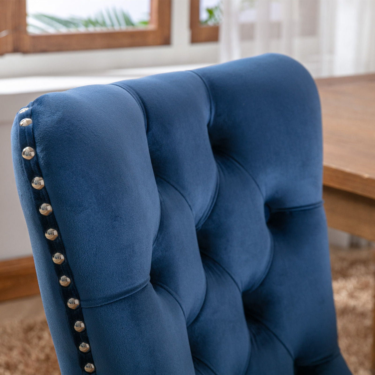 Tufted dining chair set in blue velvet with silver nailhead trim along edge backrest close-up on Tampa Home & Garden Store