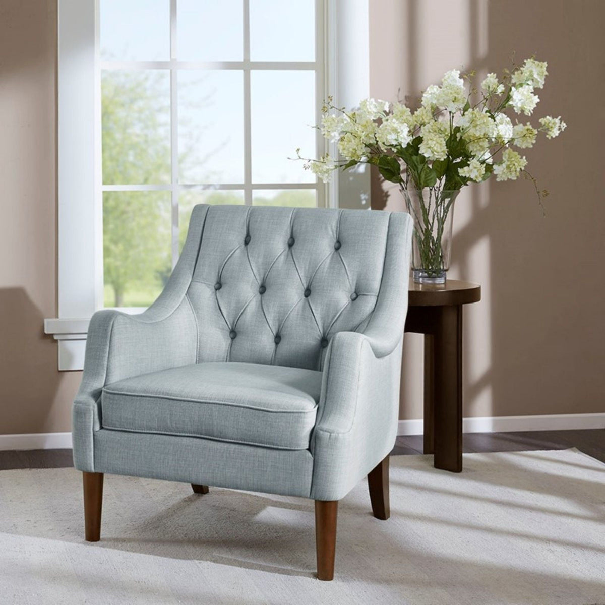 Light blue button-tufted accent arm chair with removable cushion beside a table on Tampa Home & Garden Store