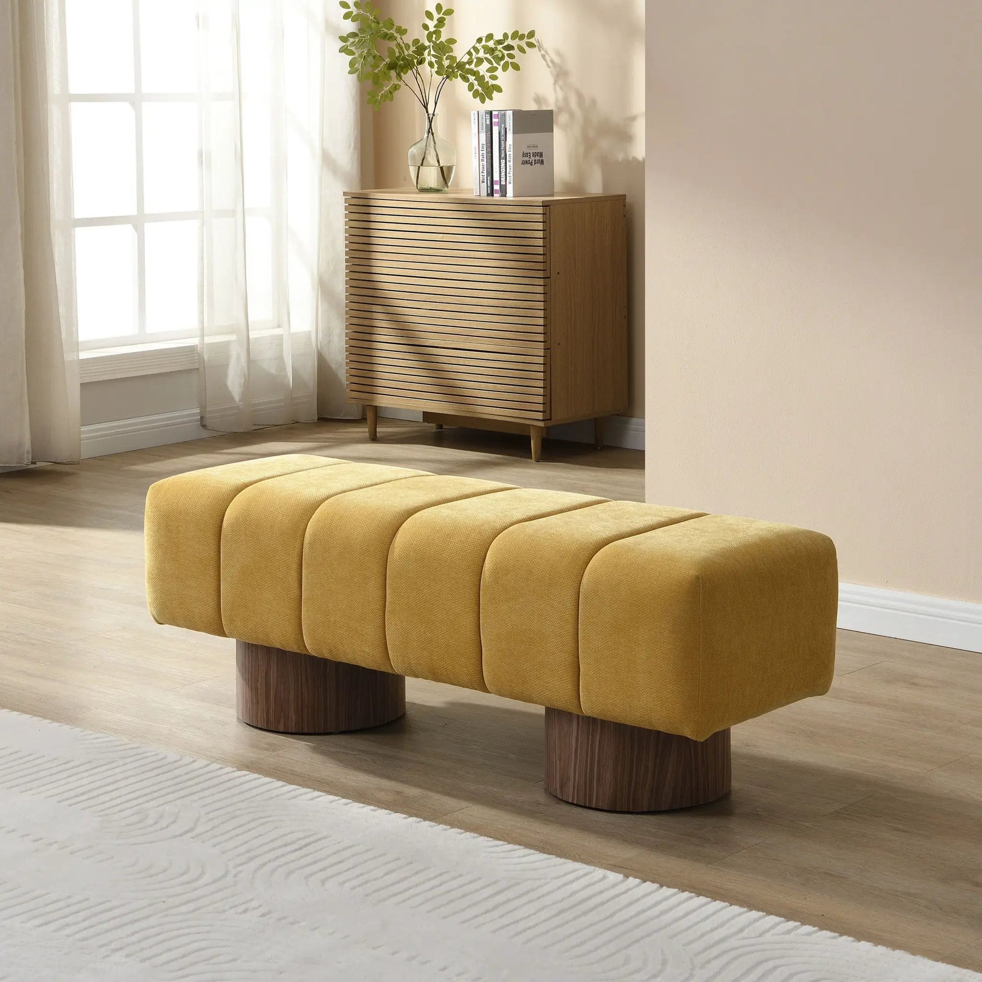 Upholstered dining bench in warm mustard fabric with segmented cushions and round wood bases on Tampa Home & Garden Store